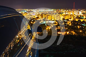 City lights reflected in car