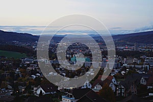 City lights of Urdorf village contrast with evening sky at sunset in pastel colours.