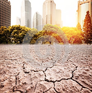 A city looks over a cracked earth landscape