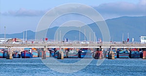 City in motion, traffic on the bridge with cars, motorcycles, buses and many people, against the blue sea, blue sky