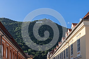 City name Brasov written with huge white letters on top of forested Mount Tampa is a recognizable city sign, Romania