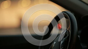 City at night background with cars through car window, steering wheel.
