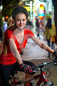 City night bicycle ride. Girls wearing bicycle helmet.