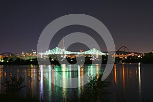 a city at night with lights reflecting in the water of a river