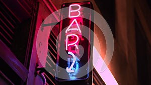 City Nightlife Neon bar sign, alcohol is available for drinking. Handheld shot