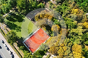 City park with basketball and soccer or football grounds at bright sunny day. Children playground in green recreation area. Aerial