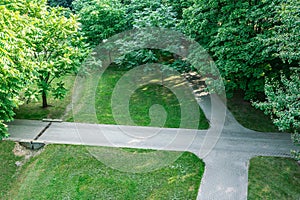 City public park with footpaths, lawn and green trees at summer morning. aerial photo