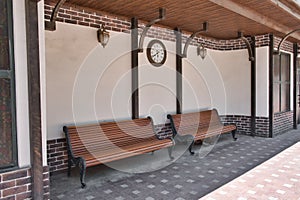 City public transport station in classic retro style with two benches and clock