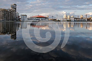 City reflected in a pond at sunset