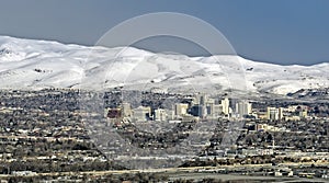 City of Reno Nevada cityscape with hotels, casinos,  a blue sky and snow capped mountains. photo