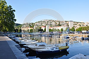 City of Rijeka Boat Port. Daily Cityscape river channel with moored barges. Rijeka city water reflections in Croatia