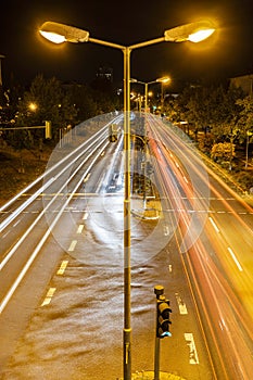 City road at night with lamp posts and light trails