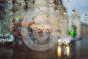 City road seen through rain drops on the car windshield