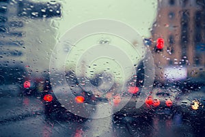 City road seen through rain drops on the car windshield