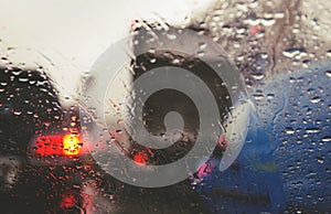 City road seen through rain drops on the car windshield