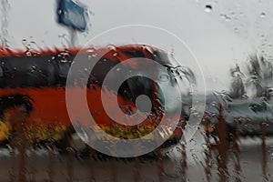 City road seen through rain drops on the car windshield