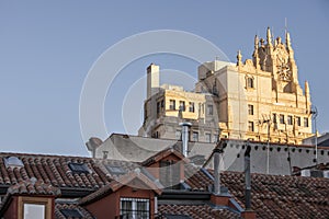 City rooftops with metal chimneys and industrial smoke vents and stately building facades bathed in morning sunbeams