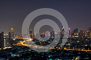 City scape of skyscrapers with lights on in the offices by night