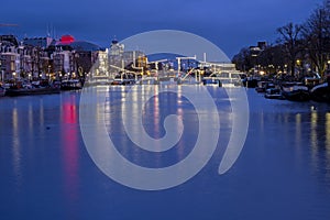 City scenic from Amsterdam at the river Amstel in the Netherlands at sunset