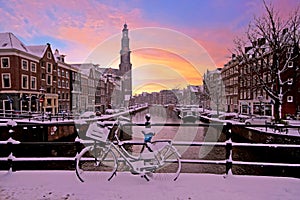 City scenic from snowy Amsterdam with the Westerkerk in Netherlands at sunset