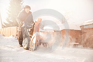 City service cleaning snow winter with thrower blower machine after snowstorm yard