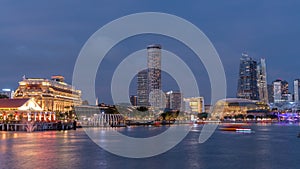 City skyline with skyscrapera and Esplanade Theatres on the Bay in Singapore at dusk, with beautiful reflection in water