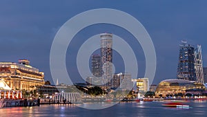 City skyline with skyscrapera and Esplanade Theatres on the Bay in Singapore at dusk, with beautiful reflection in water