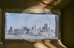 City skyline through small window of Alcatraz prison, San Francisco, CA, USA