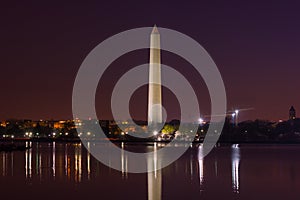 City skyline and Washington Monument at night during cherry blossom festival in Washington DC, USA.