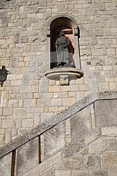 The city is the state of San Marino, the figure of the saint in a niche in the wall of the building.