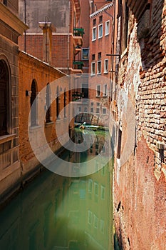 City streen canal in Venice with green water