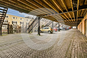 a city street with cars parked under a bridge