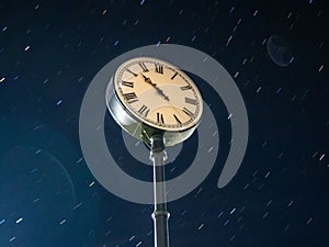City street clock on the background of the starry sky.