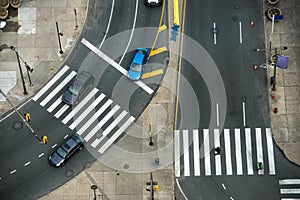 City street with crosswalks on asphalt road and car traffic.