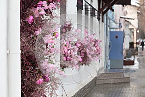 City street is decorated with artificial flowers