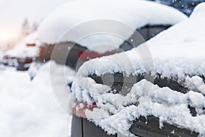 City street driveway parking lot spot with small car covered snow stuck trapped after heavy blizzard snowfall winter day