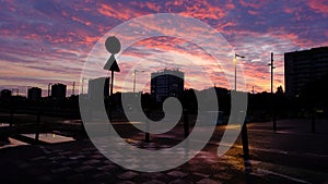 A city street at dusk with a stop sign and a traffic light