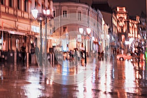 City street in rainy late evening, abstract background of blurred people figures under umbrellas, orange brown tones