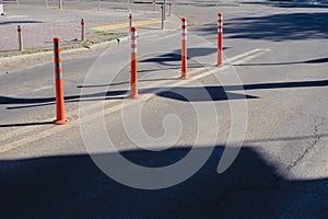 City street with road markings. Orange barrier posts on the road