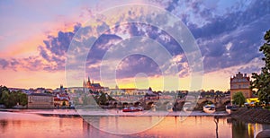 City summer landscape at sunset, panorama, banner - view of the Charles Bridge and castle complex Prague Castle in the historical