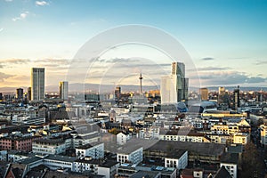 City surrounded by modern buildings under a cloudy sky during sunset