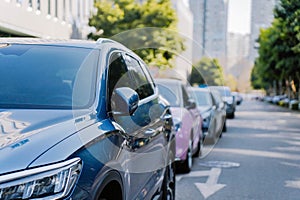 City traffic with cars parked in line on street side.