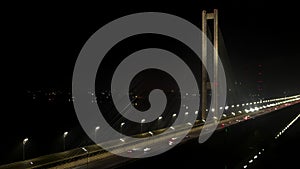 City traffic on the modern bridge in the fog at the night aerial view