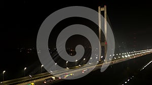 City traffic on the modern bridge in the fog at the night aerial view