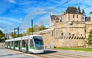 City tram at the Castle of the Dukes of Brittany in Nantes, France photo