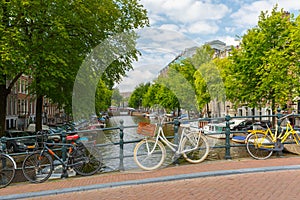 City view of Amsterdam canal, bridge and bicycles, Holland, Netherlands.