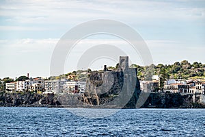 Cityscape of Aci Castello with historical Castello Normanno castle landmark with shadows