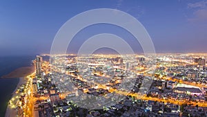 Cityscape of Ajman from rooftop day to night aerial timelapse