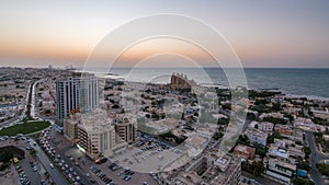 Cityscape of Ajman and Sharjah day to night timelapse from top photo