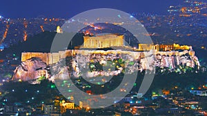 Cityscape of Athens with illuminated Acropolis hill, Pathenon and Herodium construction and sea at night. Athens skyline at night